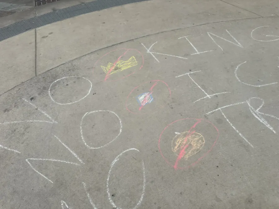 NO KINGS written on the ground near the chalk wall