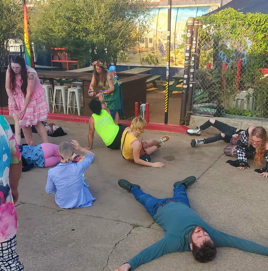 The audience lying on the pavement with their eyes closed during Tepani's hypnotism exercise.