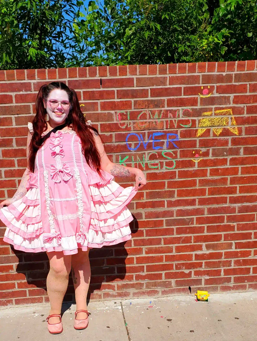 Tepani the clown curtseying next to her 'graffiti'