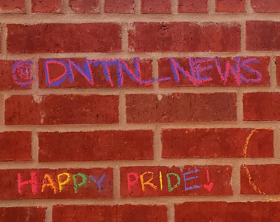 DNTN's logo written in chalk on the wall.