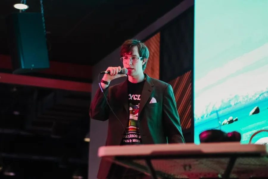 Tyler Puryer stands on stage, hosting the show.