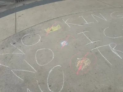 NO KINGS written on the ground near the chalk wall