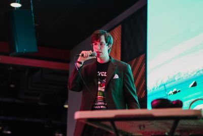 Tyler Puryer stands on stage, hosting the show.