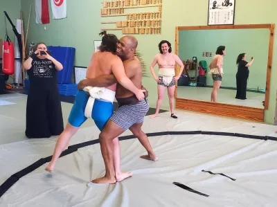 Jared and another member wrestle, smiles on both of their faces.